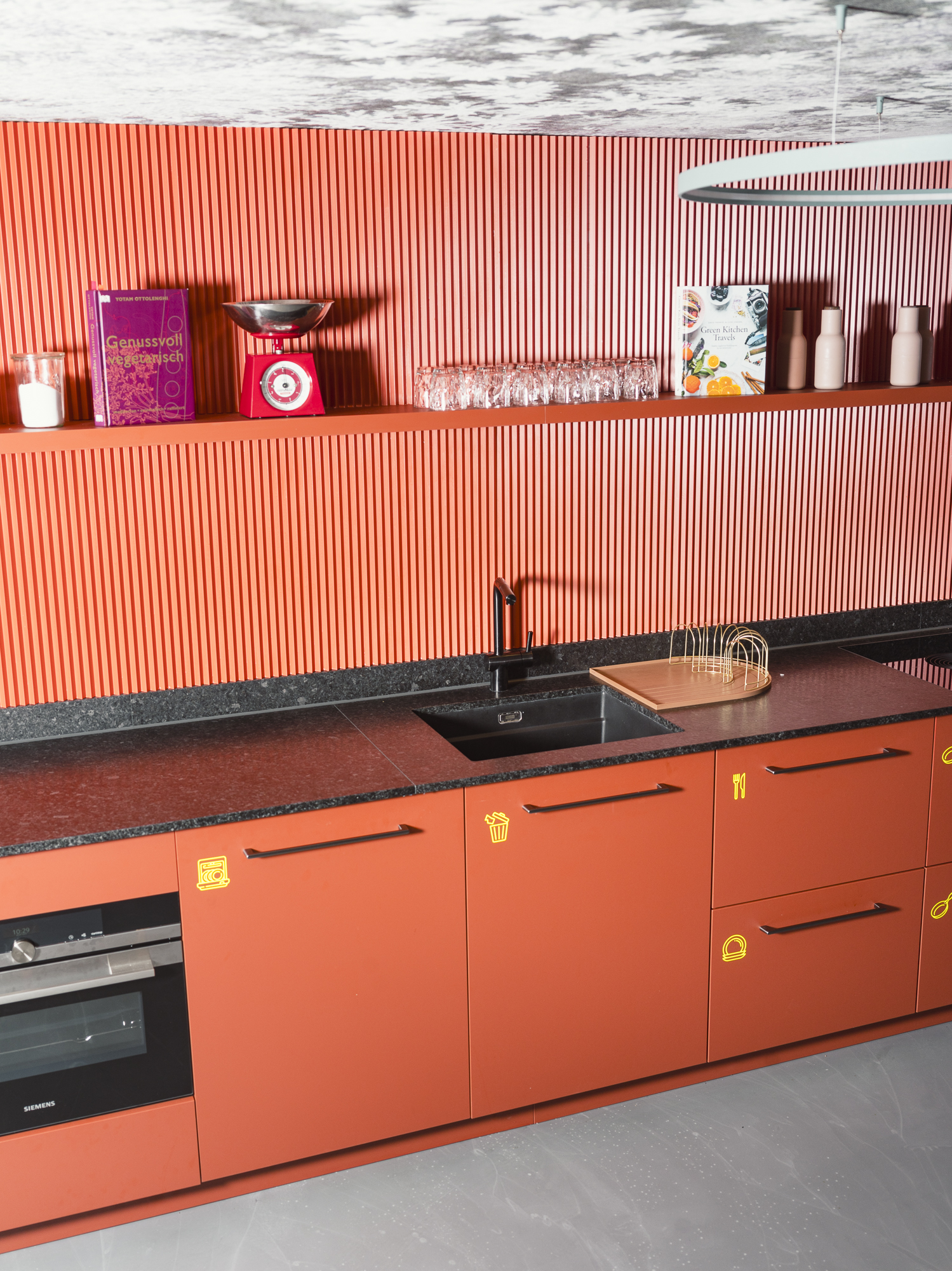 Accommodation with a red kitchenette for self-catering at the Breitach Hus in Kleinwalsertal.